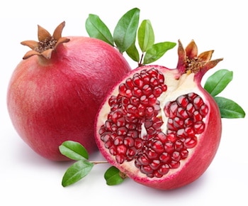 Juicy pomegranate and its half with leaves. Isolated on a white background. Granatapfel